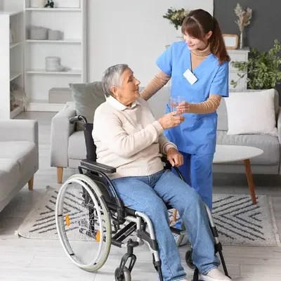 stock-photo-senior-woman-wheelchair-taking-glass-water-caregiver-home